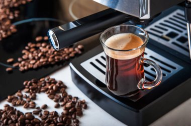 Şeffaf fincan kahve, yakın çekimde. Ev yapımı kahve makinesi ve kahve yapma süreci. Kahve çekirdekleri ve kopyalama alanından ayrıl.