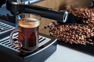 Şeffaf fincan kahve, yakın çekimde. Ev yapımı kahve makinesi ve kahve yapma süreci. Kahve çekirdekleri ve kopyalama alanından ayrıl.