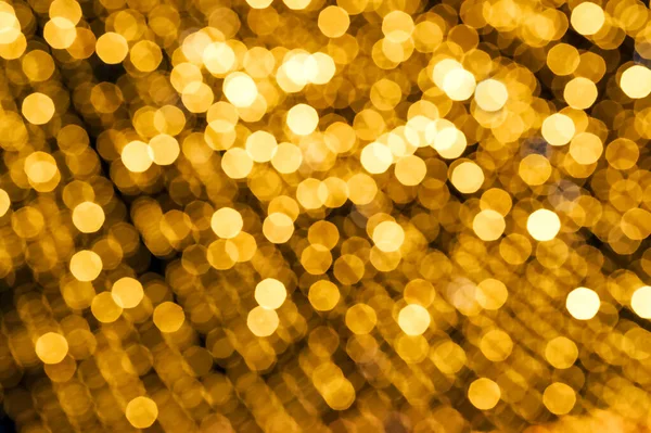 Christmas background gold lights in defocus. Yellow lights on a black background place for text.