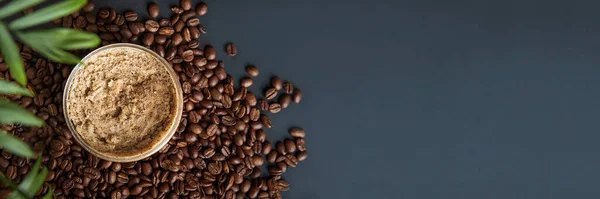Coffee body scrub and coffee beans on dark background banner. Skincare, health care concept.