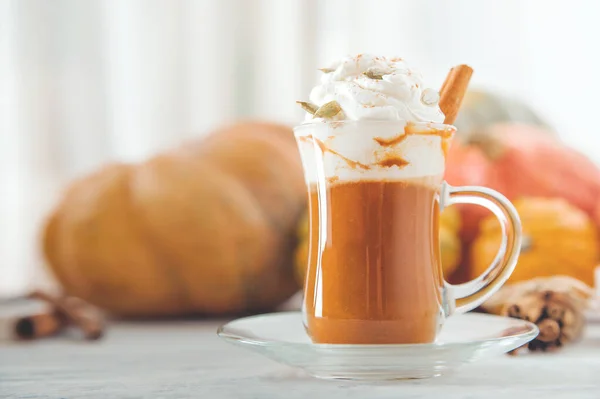 Pumpkin coffee in transparent cup and whipped cream with cinnamon. Autumn cappuccino or latte menu. — Stock Photo, Image