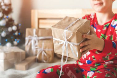 Noel ağacının arka planında çocukların hediyesini yakın plan çekeceğiz. Yeni yıl havası, hediye paketi, Noel sabahı