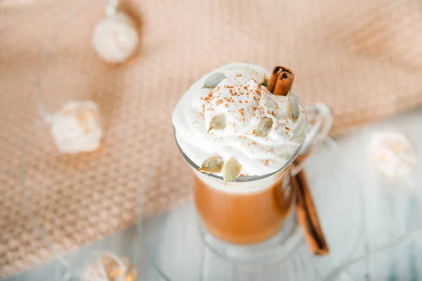 Kürbiskaffee in durchsichtiger Tasse und Schlagsahne mit Zimt. Herbst-Cappuccino oder Latte-Menü. — Stockfoto