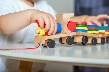 Yakışıklı çocuk anaokulunda ya da çocuk odasında ahşap oyuncaklarla oynar....