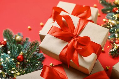 Kırmızı Kurdeleli Noel hediyesi kutuları ve Kırmızı Arkaplanda Festivalsel Dekorasyonlar.