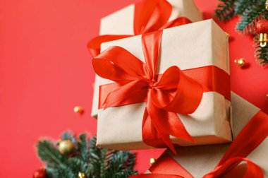 Kırmızı Kurdeleli Noel hediyesi kutuları ve Kırmızı Arkaplanda Festivalsel Dekorasyonlar.