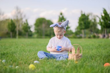 Gülümseyen Çocuk Paskalyayı Yumurta Avı Sepeti ile kutluyor.