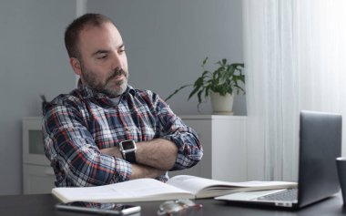 Ev ofisinden bilgisayar ve kağıtlarla çalışan serbest çalışan bir iş adamı. Masasında rahat televizyon çalışmalarının keyfini çıkarıyor. Serbest meslek ve serbest meslek kavramı