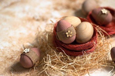 Pastel mermer arka planda bir yuvada paskalya yumurtaları. Mutlu Paskalya tebrik kartları. Kırsal Paskalya dekorasyonu. Paskalya yakın kompozisyonu