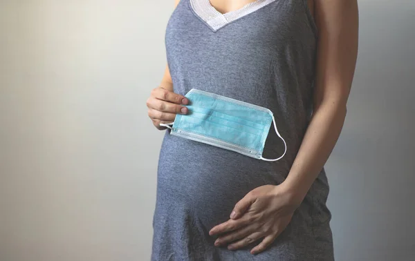 Hamile Bir Kadın Hamile Karnının Yanında Koruyucu Bir Tıbbi Maske — Stok fotoğraf