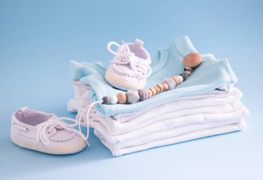 Mavi arka planda bebek kıyafetleri ve aksesuarlarının yakın plan görüntüsü