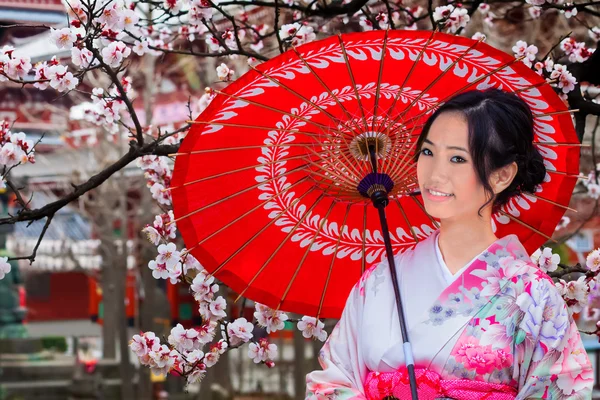 Jovem mulher japonesa em um jardim japonês no outono — Fotografia de Stock