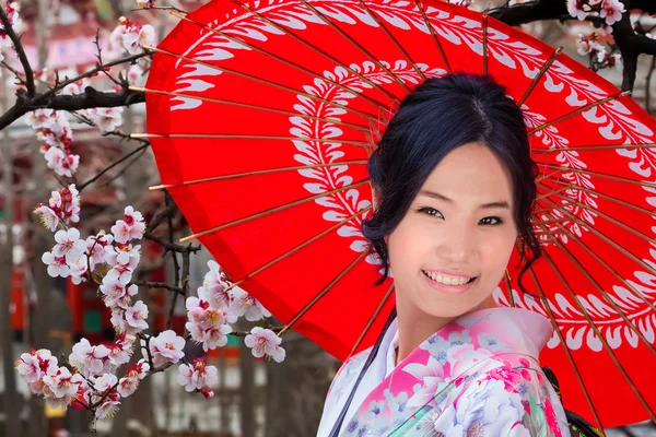 Jovem mulher japonesa em um jardim japonês no outono — Fotografia de Stock