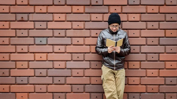 Un hombre asiático en una chaqueta marrón con un pequeño cuaderno en — Foto de Stock
