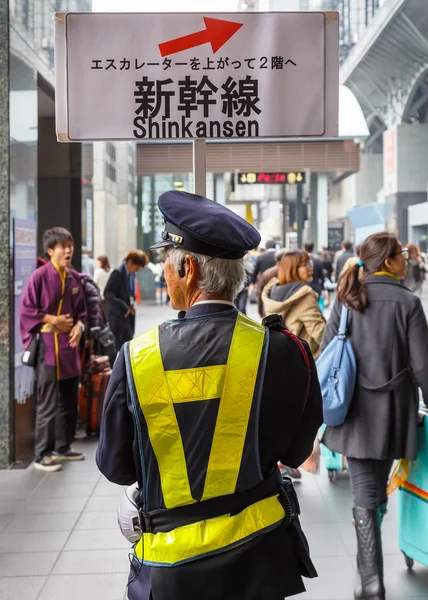 Japonský dělník ukazuje směr znamení Šinkanzen platformy v Kyoto Station — Stock fotografie