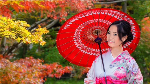 Giovane donna giapponese in un giardino giapponese in autunno — Foto Stock