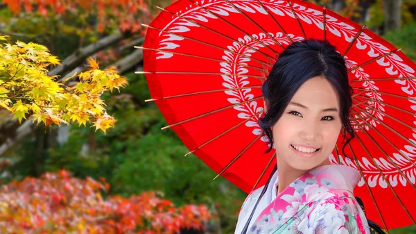 Giovane donna giapponese in un giardino giapponese in autunno — Foto Stock