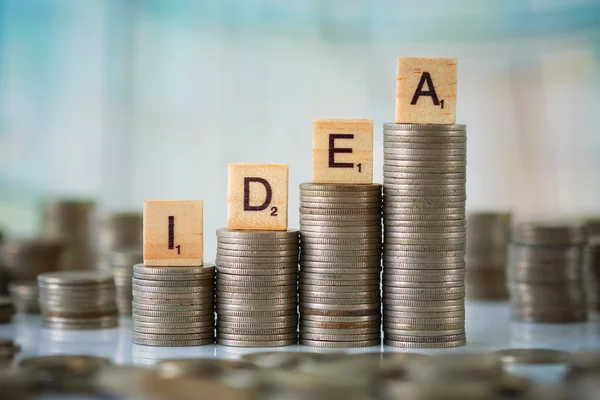 Stack of Coins with Wooden Scrabble Letters — Stock Photo, Image