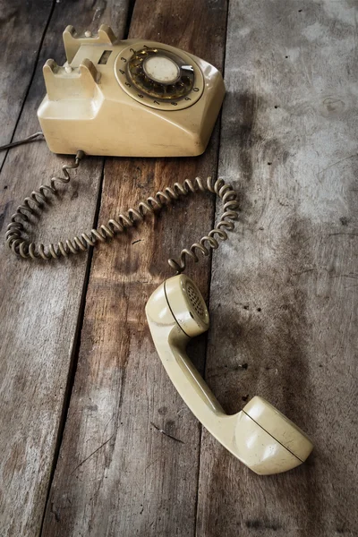 Винтажный телефон на старом деревянном столе — стоковое фото