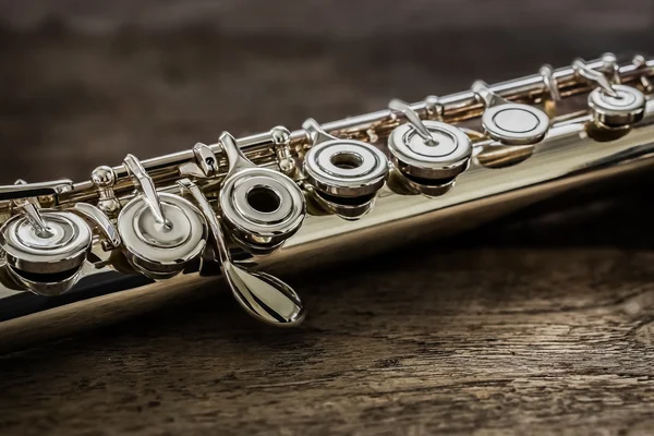 Современная концертная флейта на деревянном столе — стоковое фото
