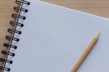 Boş bir defter üzerinde yerleştirilmiş ahşap kalem