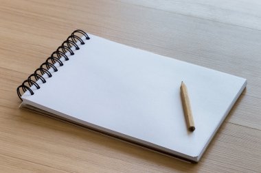 Boş bir defter üzerinde yerleştirilmiş ahşap kalem