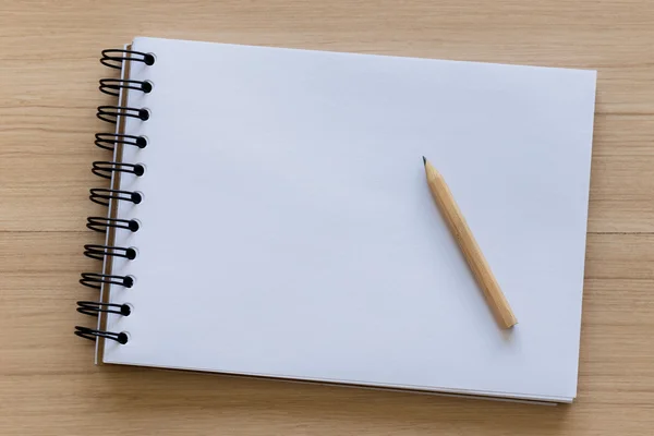 Lápiz de madera colocado en un cuaderno en blanco — Foto de Stock