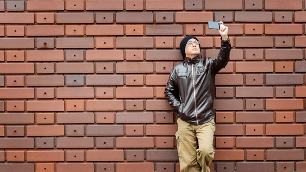 An Asian Man in a Brown Jacket with His Smartphone — Stock Photo, Image