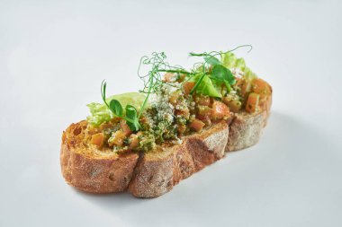 İtalyan aperatifi - domatesli bruschetta ve çavdar ekmeğine pesto sosu. Beyaz arka plan. Seçici odak