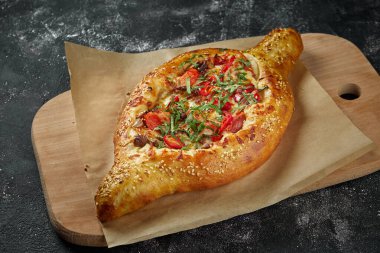 Türk yemeği - dilimlenmiş et, ahşap tahtada domates. Siyah arka plan. görünümü kapat