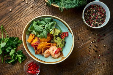 İştah açıcı Meksika aperatifi avokado guacamole ile karides, sebze cipsi ve ahşap arka planda kişniş. Görüntüyü kapat