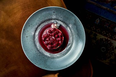 Kiraz ve reçelli iştah açıcı bir parça çikolatalı pasta, muhallebi, mavi bir tabakta servis edilir. Restoranda tatlı servis ediliyor.