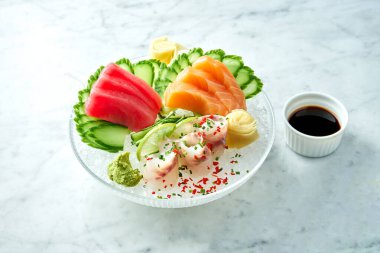 Klasik Japon saşimi seti çiğ somon, limonlu ton balığı mermer zemin üzerinde salatalık. Yaklaş, seçici odaklanma