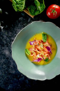 Peru mutfağı tabağı - acı biber, soğan ve sarı soslu somon ceviche, mermer zemin üzerinde mavi bir tabakta servis edilir. Restoran deniz ürünleri..