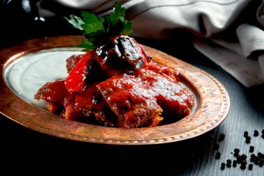 İnce dilimlenmiş kuzu ızgarasından yapılmış İskender kebabı üzerine sıcak domates sosu, pide ve erimiş koyun sütü yağı ve yoğurt.