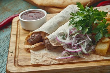 Tahta bir tahtanın üzerinde ızgara Türk kuzu kebabı, patates, soğan ve pirinç. Ahşap arkaplan.