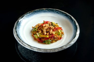 Fıstıklı, sebzeli ve soğanlı, beyaz kasede servis edilen tatlı ve ekşi şehriye. Yumurtalı erişte. Siyah arka planda izole edilmiş. Sokak Tayland yemeği