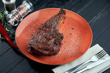 Ahşap bir arka planda ızgarada servis edilen iştah açıcı biftek. Amerikan BBQ kültürü