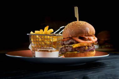 Etli, domatesli, soğanlı ve sarı soslu lezzetli burger, kırmızı tabakta Cole slow salata ile servis ediliyor. Amerikan fast food