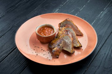 İştah açıcı diyet yemeği. Kömürde ızgara hindi filetosu. Koyu ahşap arka planda kırmızı sosla servis ediliyor. Hindi kebabı