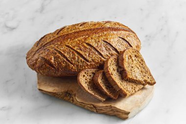 Lezzetli ve lezzetli çavdar ekmeği mermer bir zeminde tahtada. Taze pişmiş ekmek.