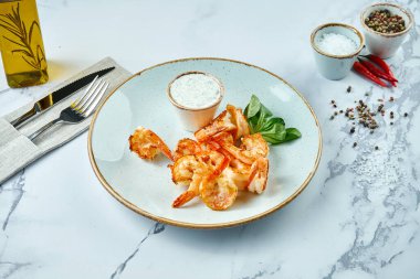 Lezzetli Akdeniz aperatifi. Sarımsak soslu ızgara kaplan karidesi. Mermer arka planda servis ediliyor. Deniz ürünleri pişmiş karides.