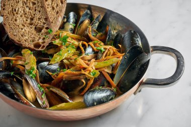 Kabuklu midye. Sebzeli midye. Beyaz mermer arka planda kızarmış ekmek.