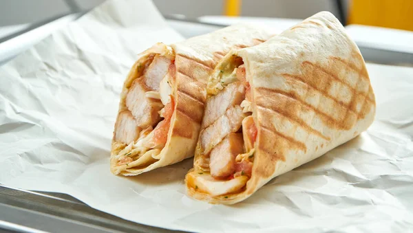 用蔬菜 酱汁和猪肉包在平塔面包里 用纸在浅色背景下食用 传统街头食物 Shawarma — 图库照片