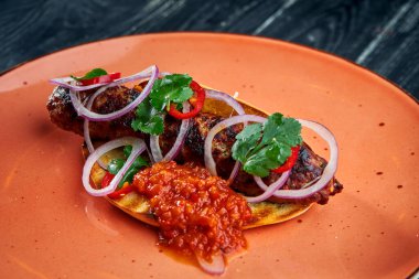 Klasik oryantal yemek, soğan ve kırmızı sosla servis edilen ızgara sığır eti ya da kuzu kebabıdır. Kara tahta arkaplan