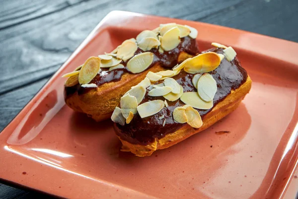 Delicious French Dessert Custard Eclairs Chocolate Icing Almonds Red Plate — Stock Photo, Image