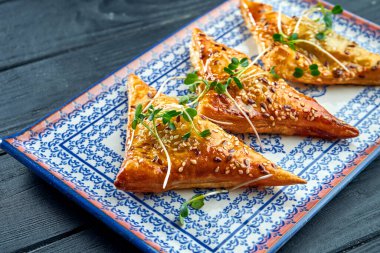 Geleneksel Türk köftesi - Burek koyu bir arka planda mavi bir tabakta servis edildi. Fillo ya da yufka gibi ince pullu hamurlardan yapılmış, tipik olarak etle doldurulmuş..