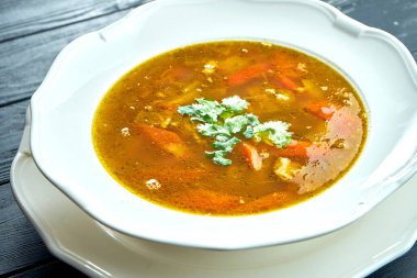 Yakın plan Chorba çorbası ya da biftek, ot ve ahşap arka planda beyaz kasede acı biber, geleneksel Türk mutfağı.