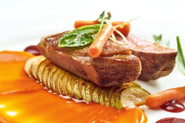 Armut ve sarı elma püresiyle iştah açıcı ördek göğsü, beyaz tabakta böğürtlen sosu. Gri arkaplanda izole.