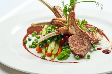 Sebze ve böğürtlen soslu ızgara kuzu eti. Beyaz arkaplanda gri.